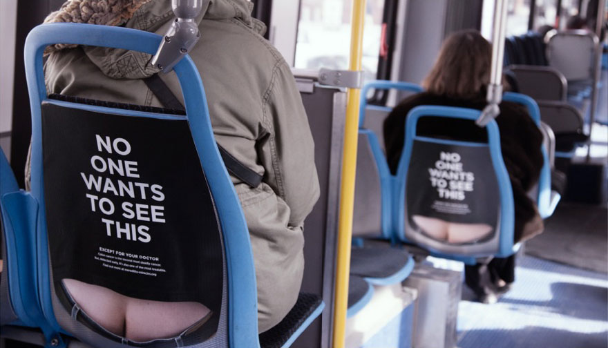 Estos anuncios en los asientos del autobús muestran la "hucha" para concienciar sobre el cáncer de colon
