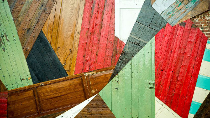 Este artista convierte viejas puertas de madera en enormes murales callejeros