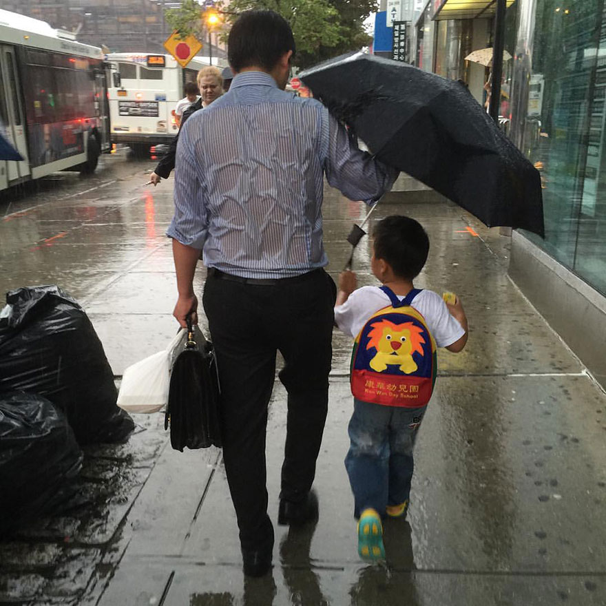 Este padre empapado protegiendo a su hijo de la lluvia muestra lo que es la paternidad