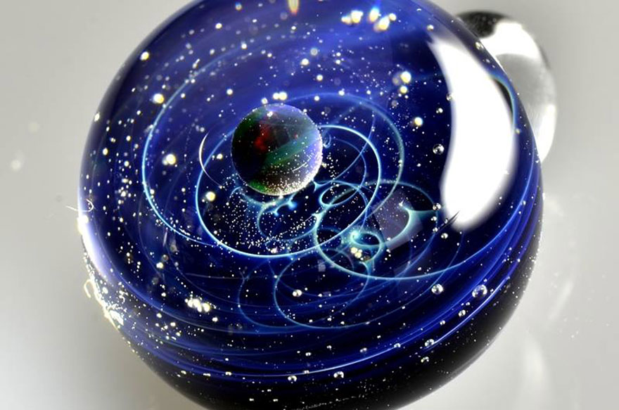 Planetas y galaxias atrapados en pequeños colgantes de vidrio creados por un artista japonés