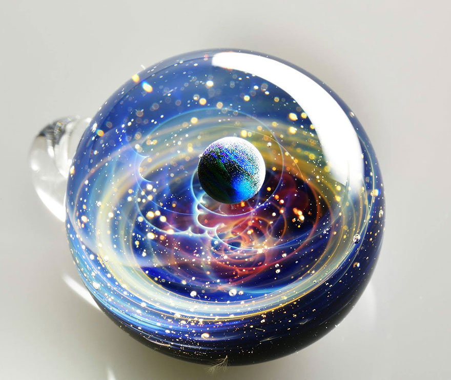 Planetas y galaxias atrapados en pequeños colgantes de vidrio creados por un artista japonés