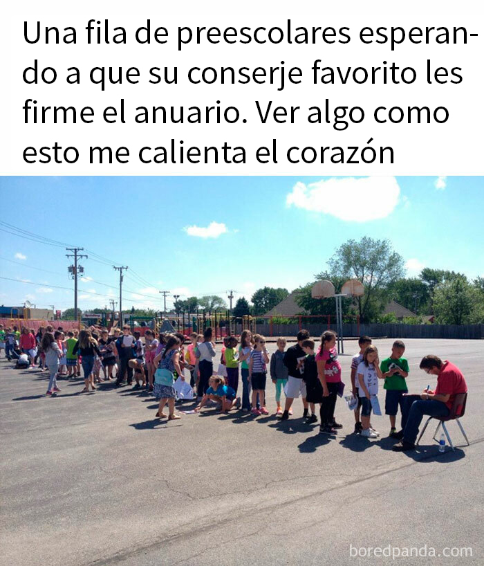 Niños en fila esperando felices para obtener autógrafo del conserje en el patio de la escuela.