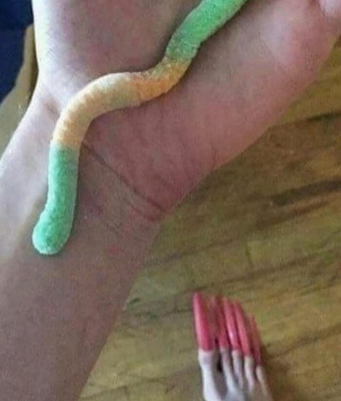 Gusanito de dulce en mano con pies pintados, imagen maldita con perspectiva difícil de explicar visualmente.