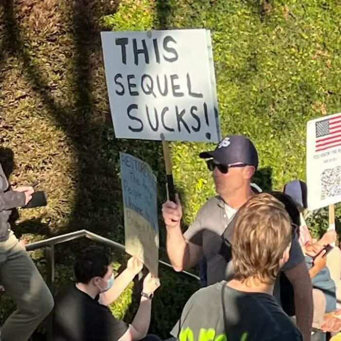 Manifestantes sosteniendo carteles en protesta, mostrando hartura contra el capitalismo y la desigualdad social.