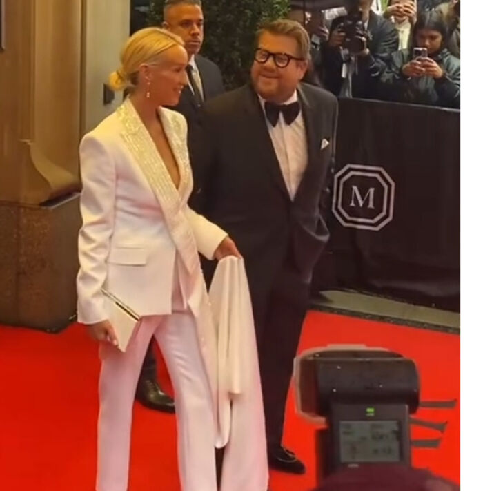 Pareja en alfombra roja durante momentos incómodos ocurridos en la Gala Met 2025, con fotógrafos de fondo.