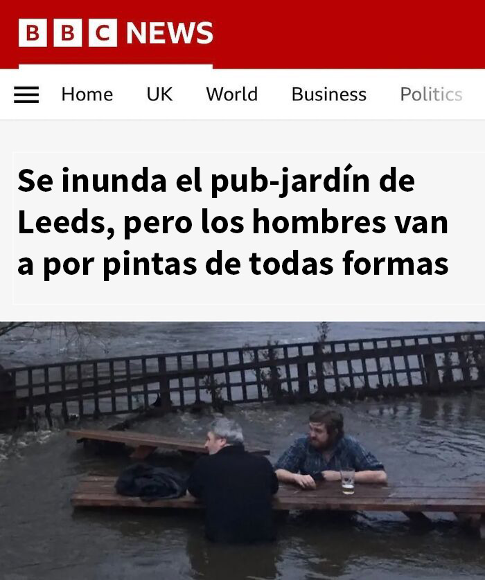 Hombres bebiendo cerveza en pub inundado en Reino Unido, mostrando humor británico fuera de contexto en imagen divertida.