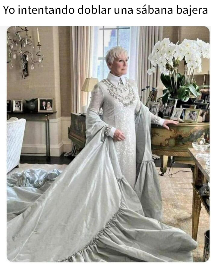 Mujer elegante con vestido largo sosteniendo una sábana bajera gigante en un meme aleatorio divertido y caótico.