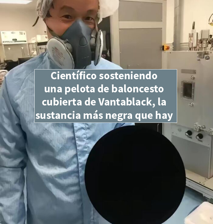 Científico con mascarilla sostiene una pelota cubierta de Vantablack, material negro utilizado en publicaciones interesantes.