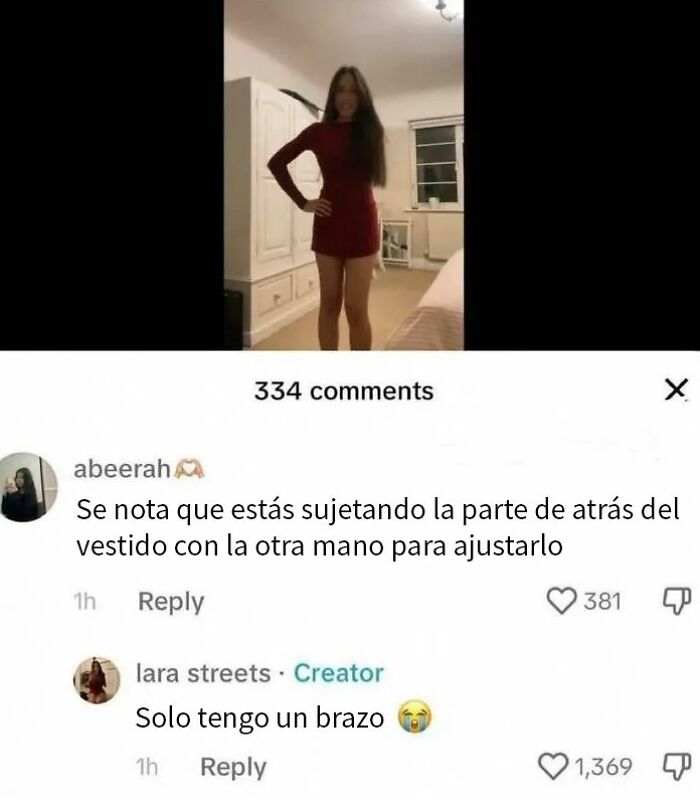 Mujer con un brazo respondiendo con humor a comentarios en redes sociales mientras lleva un vestido rojo.