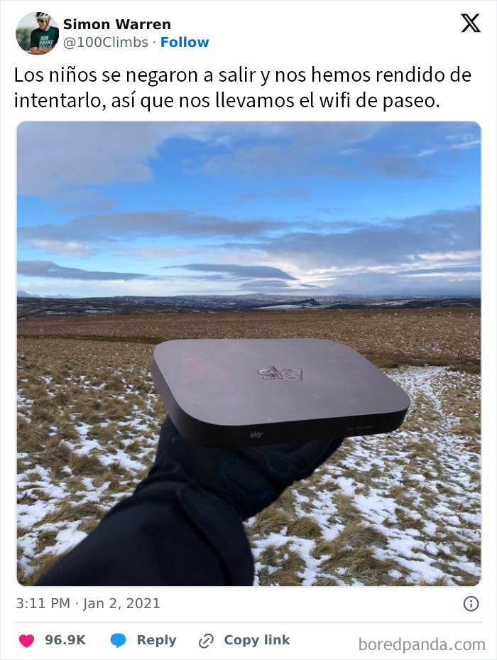 Dispositivo WiFi en mano en campo nevado, ilustrando humor y creatividad de padres divertidos en situaciones cotidianas.