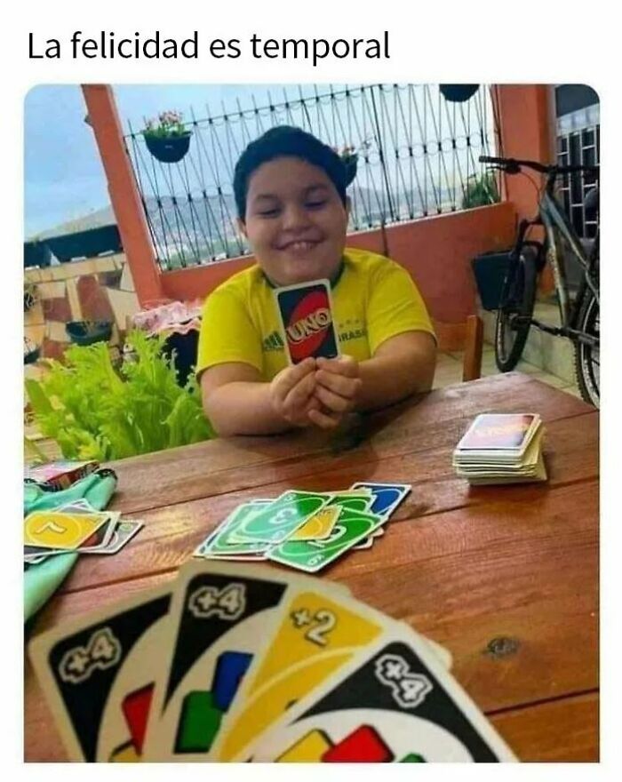 Niño sonriente sostiene carta de Uno segundos antes de que todo salga espectacularmente mal en una partida intensa.