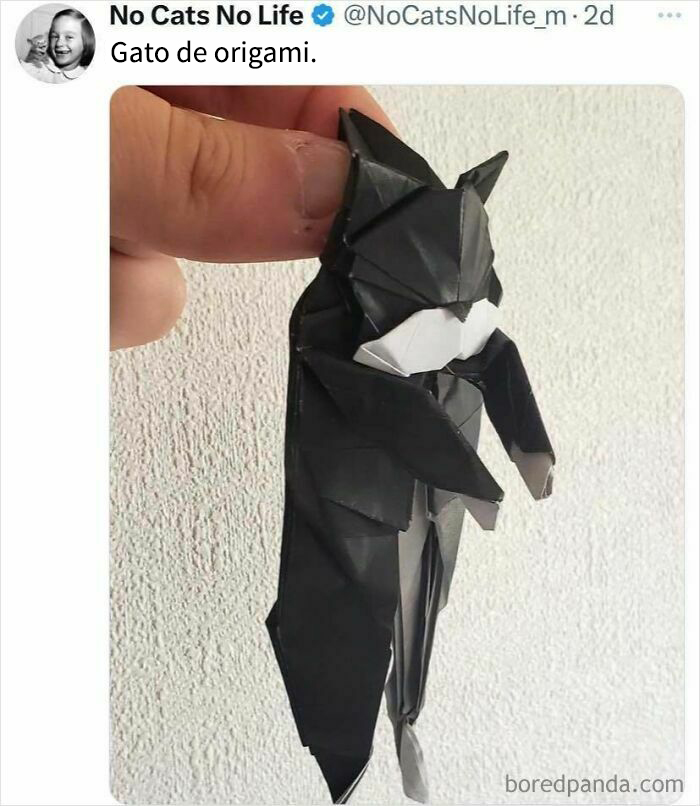 Mano sosteniendo un gato de origami negro, meme amable para mejorar un mal día con imágenes positivas y entrañables.