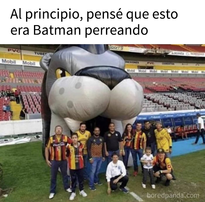 Personas posando frente a una figura gigante con humor oscuro, meme divertido para quienes disfrutan de humor con un toque oscuro.