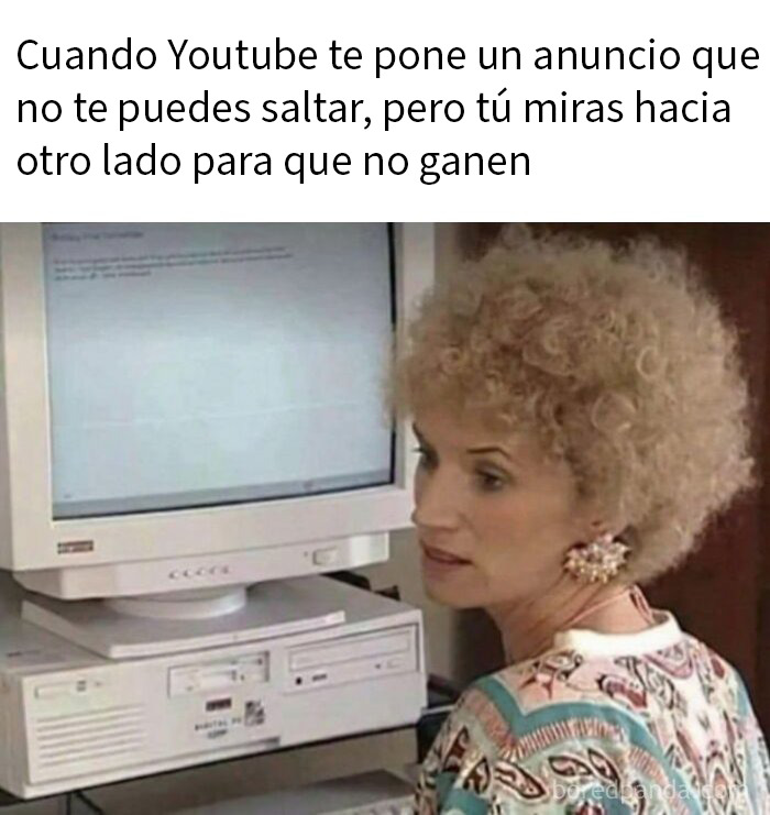 Mujer con expresión seria frente a computadora vintage, meme divertido relacionado con publicaciones para hacer reír a la gente.