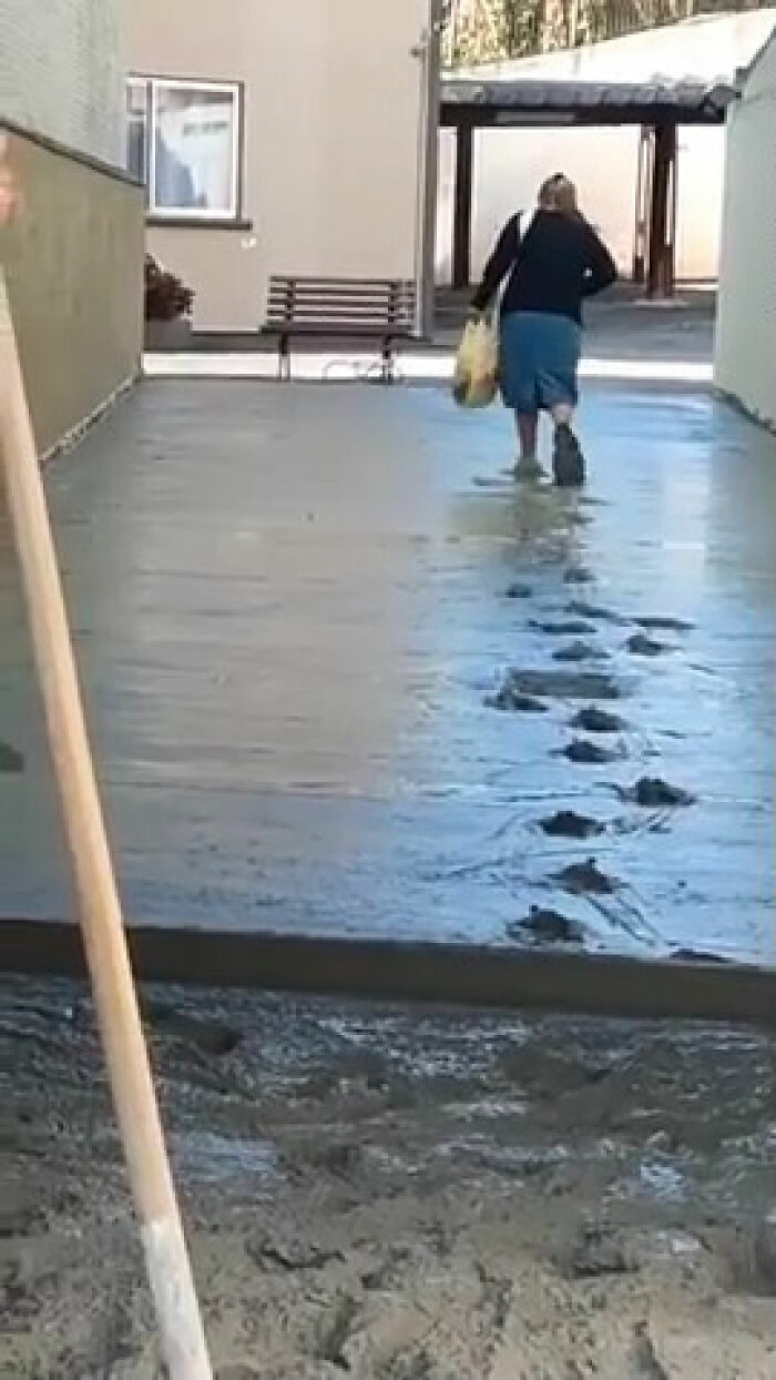Mujer egocéntrica camina sobre cemento fresco dejando una fila de huellas marcadas