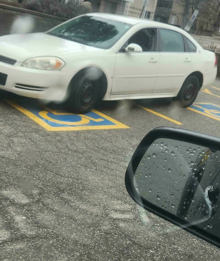 Conductor egocéntrico estaciona su auto blanco ocupando dos lugares para personas con discapacidad