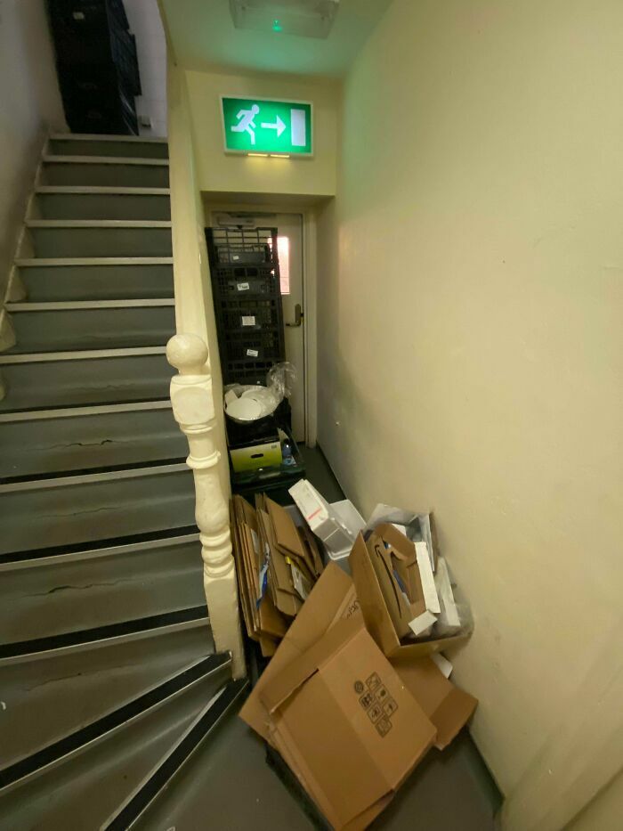 Salida de emergencia obstruida por cajas de cartón, un peligro causado por los peores jefes.