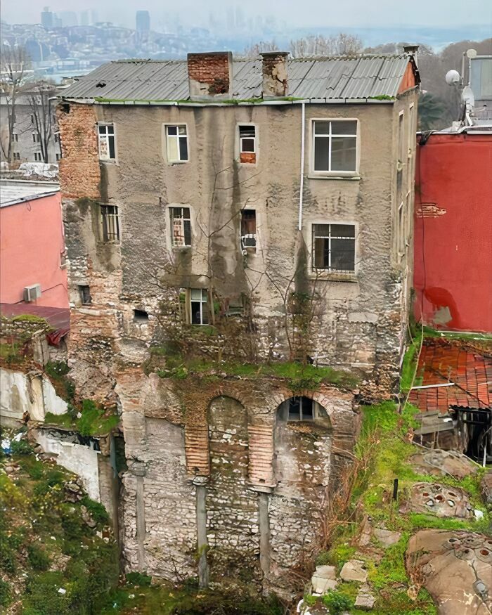 Fachada de un edificio antiguo con ruinas históricas integradas en la base