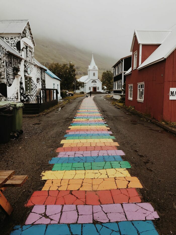Un camino peatonal pintado con los colores del arcoíris en un pueblo, entre las cosas curiosas del diseño urbano.