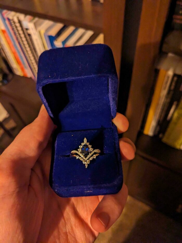 Anillo de compromiso de zafiro roto en su caja azul, un momento triste que puede empeorar