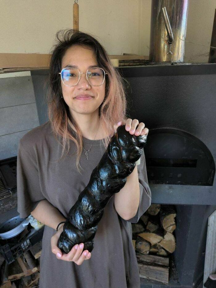 Mujer sosteniendo pan trenzado quemado y negro, fotos para cuando crees que siempre puede empeorar