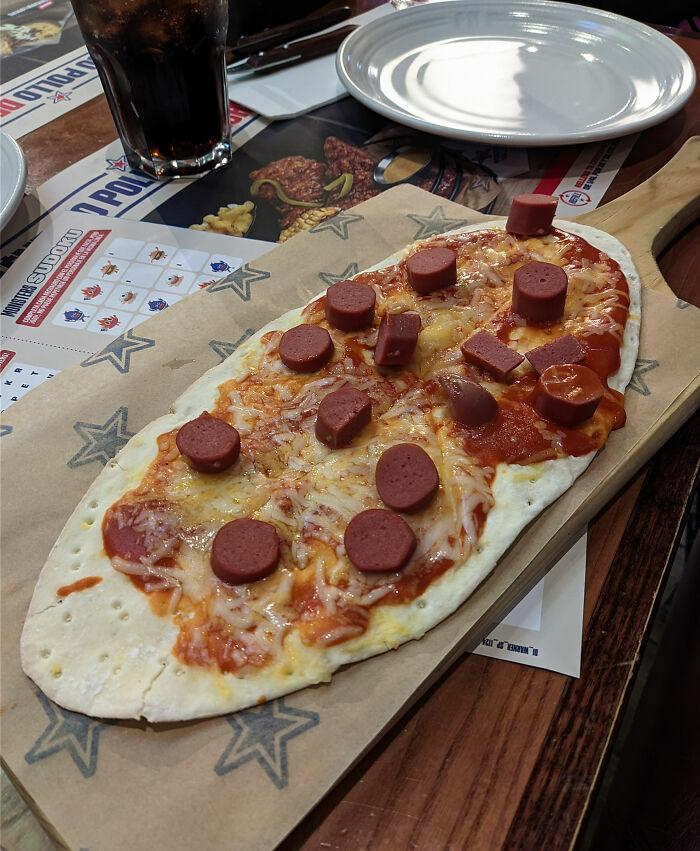 Una pizza mal hecha con salchichas baratas que ilustra cómo tener un mal día siempre puede empeorar.