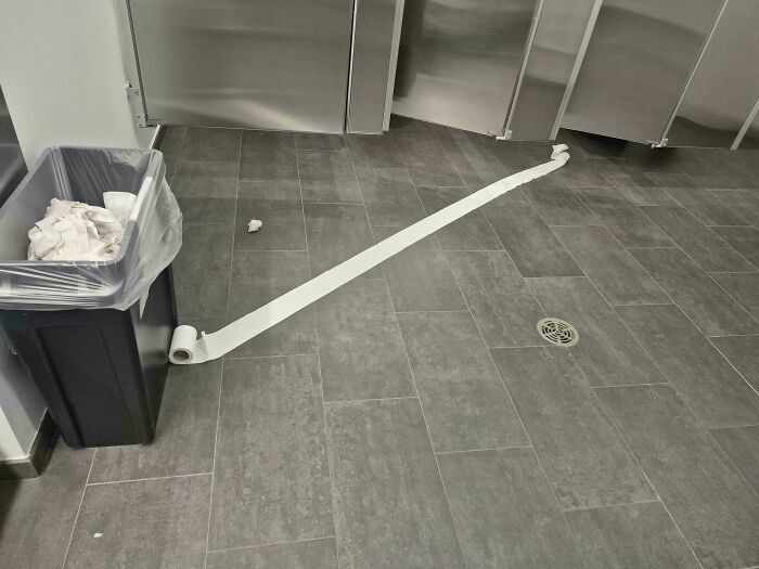 Rollo de papel higiénico desenrollado en el suelo de un baño público para ilustrar que siempre puede empeorar