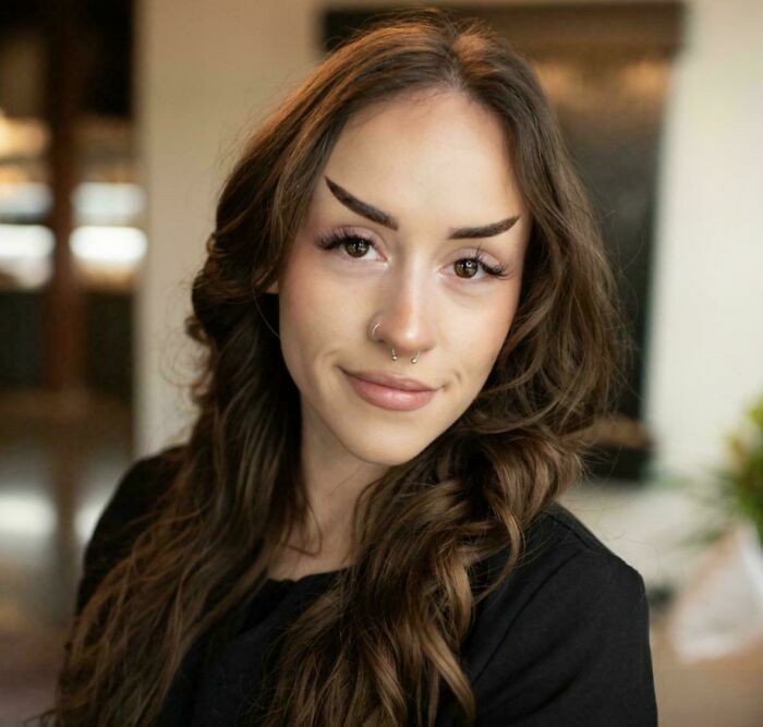 Mujer con cejas finas y arqueadas de forma inusual hechas en el salón de belleza.