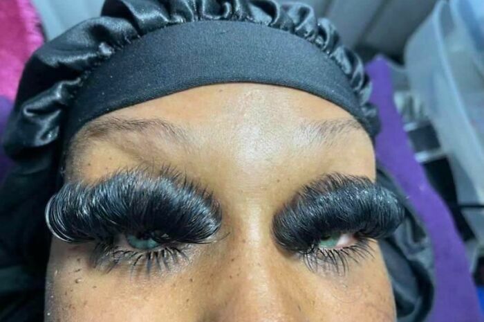 Primer plano de mujer con extensiones de pestañas exageradas del salón de belleza.