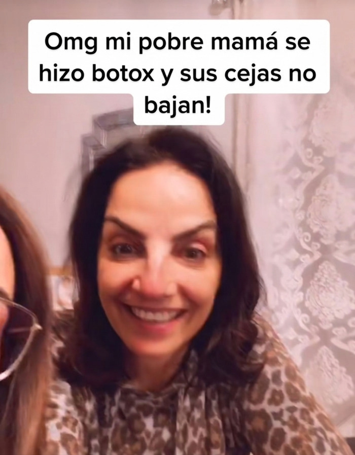 Mujer sonríe con cejas levantadas tras tratamiento en el salón de belleza.