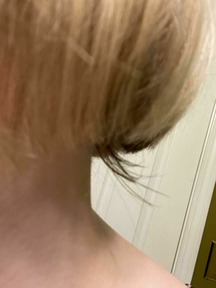 Un mal corte de pelo en un salon de belleza que muestra capas desiguales y mechones largos sin sentido.