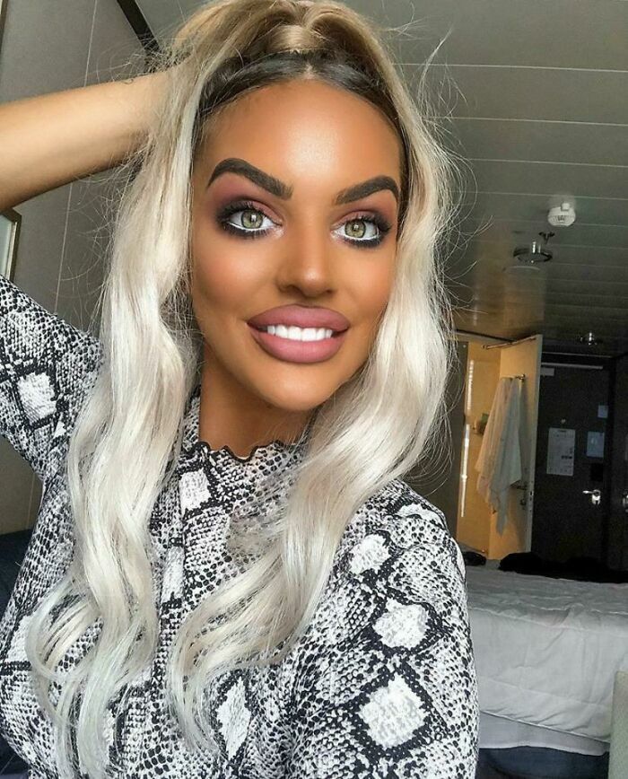 Mujer rubia con un bronceado artificial excesivo y disgustada con el resultado del salon de belleza