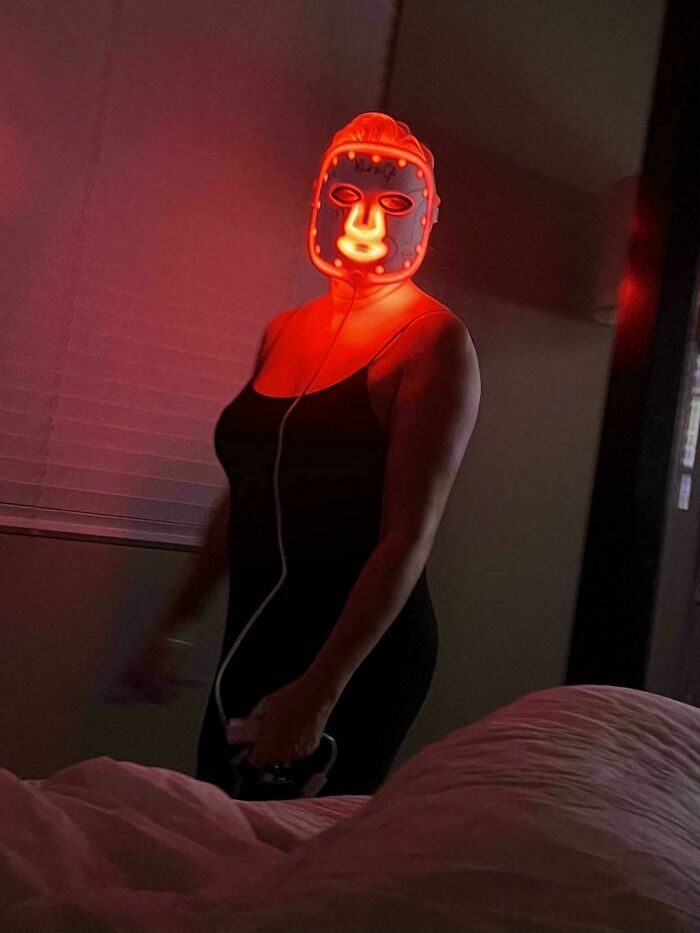 Mujer usando una máscara de terapia LED roja en la oscuridad, entre los errores tontos de novias y esposas.