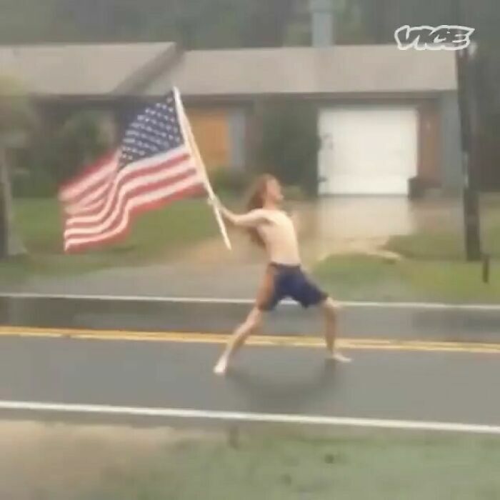 Hombre sin camisa con bandera de EE. UU. en la tormenta, reflejando memes de Florida.
