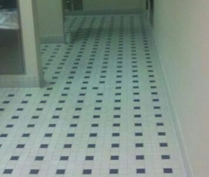 Piso de mosaicos blancos y negros con un error de alineación evidente.