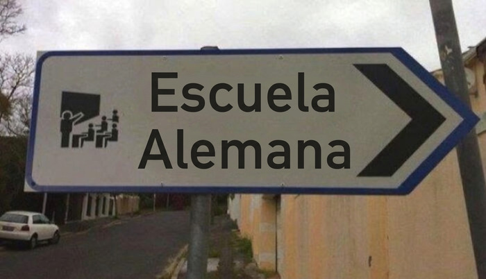 Cartel de escuela alemana que apunta en la direccion equivocada, personas que solo tenian 1 cosa que hacer
