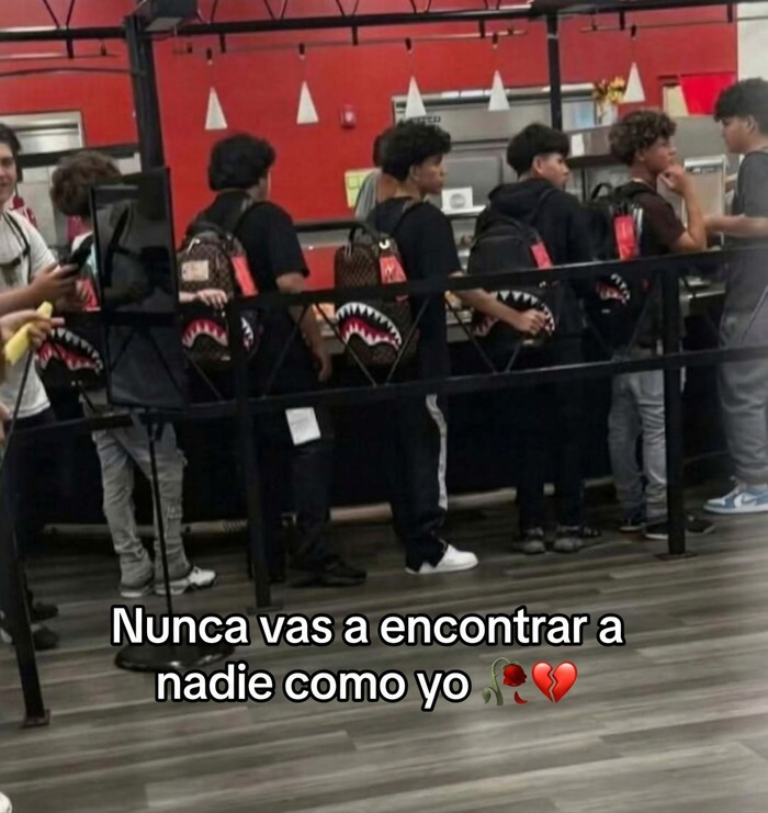 Fila de jóvenes idénticos con mochilas iguales que causa risa y vergüenza ajena