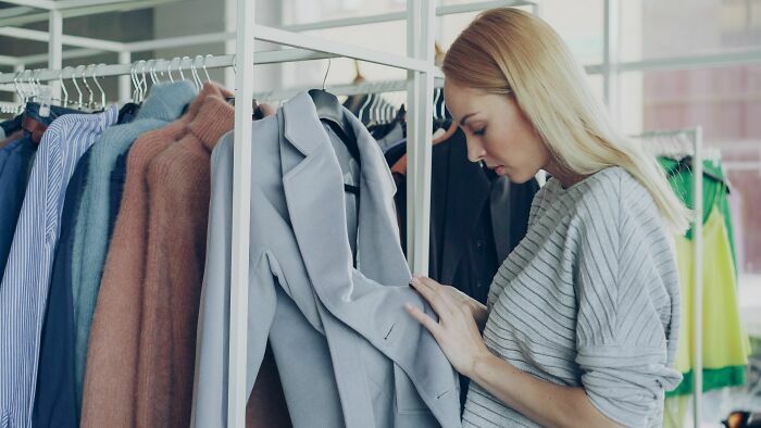 Mujer revisando ropa en tienda fisica, industrias que estan a punto de colapsar en el sector retail