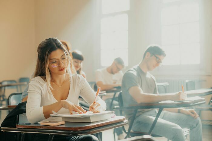 Estudiantes en un salón de clases universitario, relacionado con las industrias educativas que podrían colapsar.