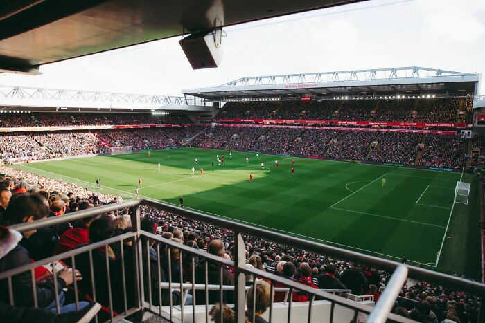 Estadio de fútbol lleno de gente que representa las industrias que están a punto de colapsar.