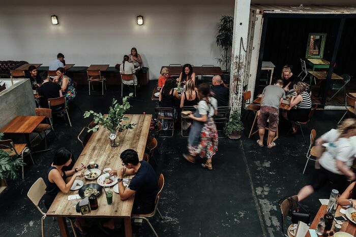 Clientes cenando en un restaurante concurrido, sector entre las industrias que están a punto de colapsar.
