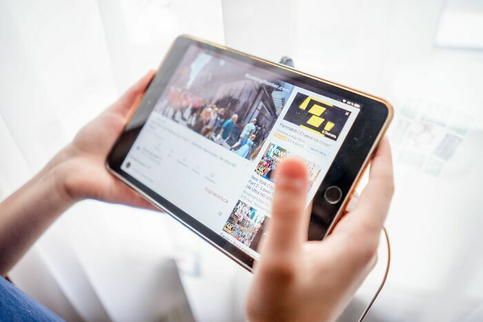 Persona usando una tableta para ver videos, mostrando el cambio digital en las industrias que van a colapsar