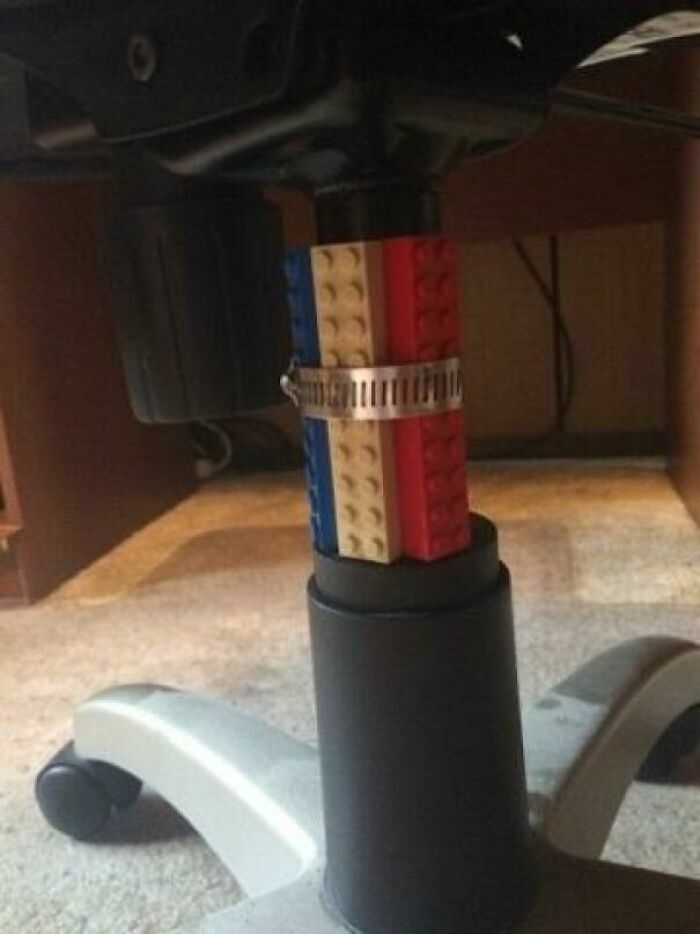 Silla de oficina reparada con bloques de construcción de juguete y una abrazadera de metal, proyectos caseros.