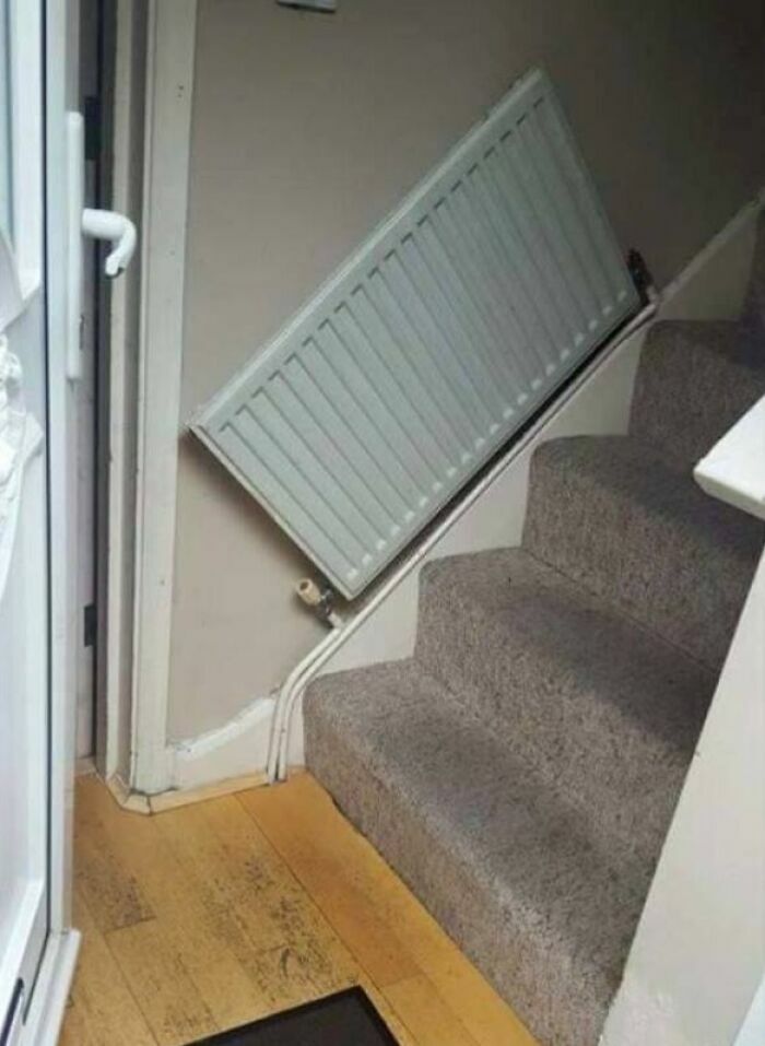 Instalación de radiador torcido en la escalera, un ejemplo de proyectos caseros fallidos.