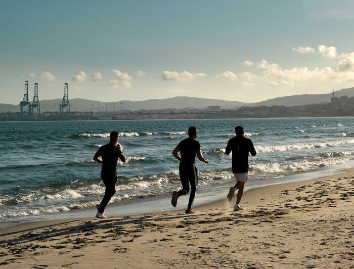 Tres personas corriendo por la playa, una situación donde se pueden confundir gemelos