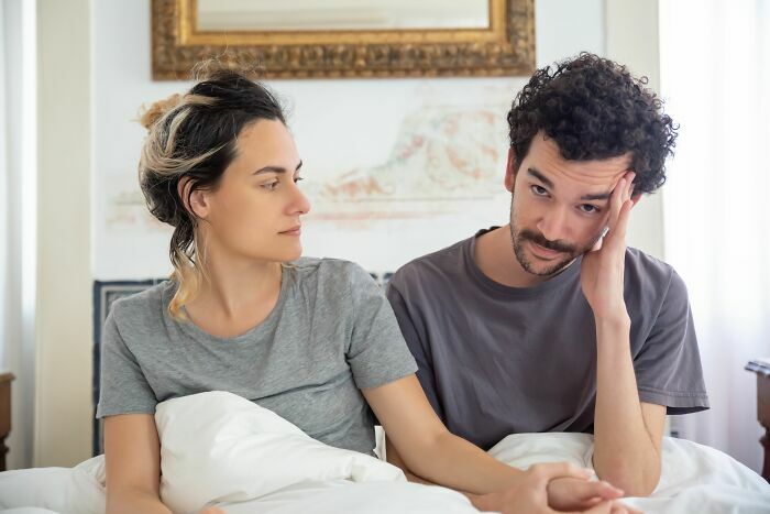Pareja en la cama conversando sobre divertidas historias de gemelos confundidos