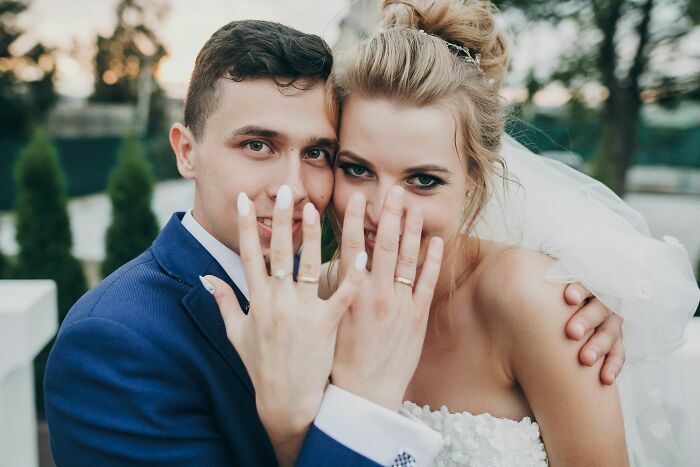 Pareja recién casada mostrando sus anillos tras una de las historias de gemelos confundidos