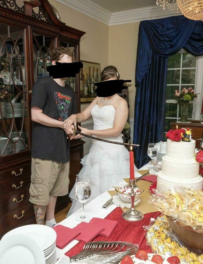 Pareja cortando el pastel de bodas con una espada katana en la recepción.