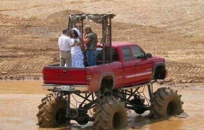Pareja celebrando una de las bodas más insólitas sobre un camión monstruo en el lodo