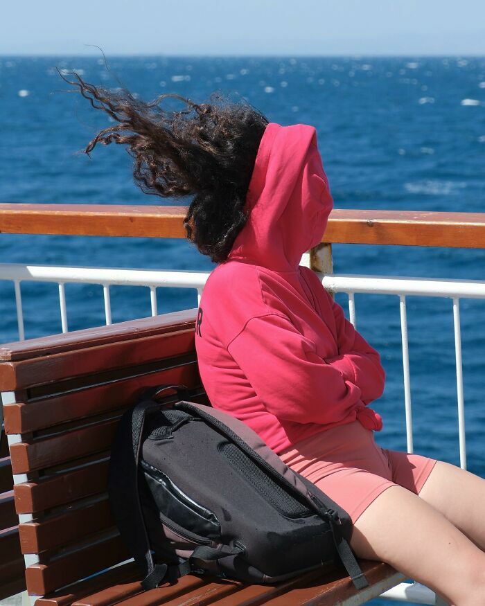 Persona en un barco con el pelo al viento, ejemplo de escenas callejeras captadas en el momento justo.